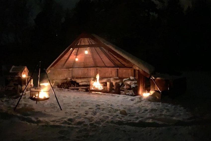 A snow-covered landscape with a wooden cabin and two lanterns. 3