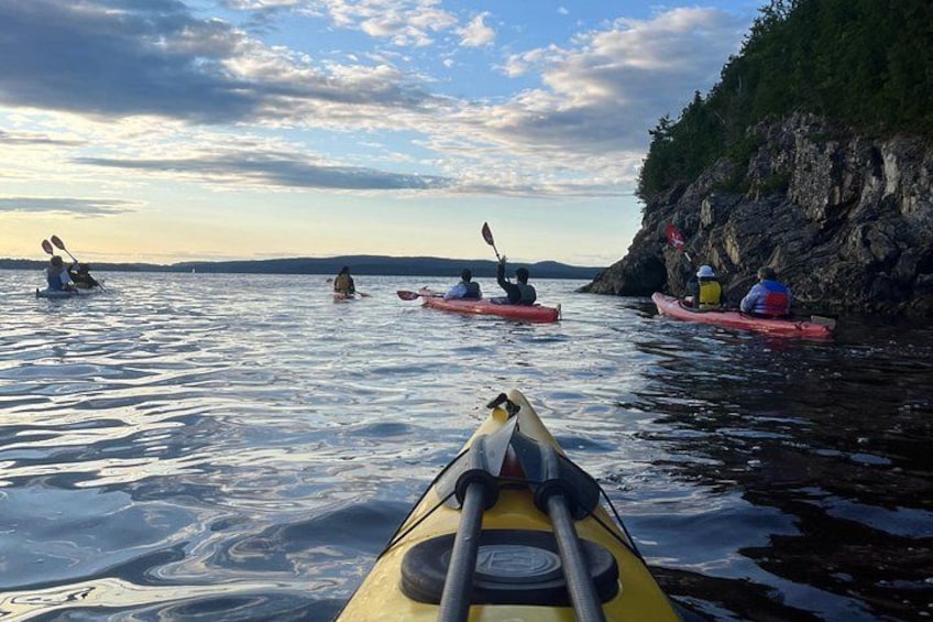 Un groupe de personnes pratiquant le kayak sur un lac paisible, bordé de rives rocheuses. 4