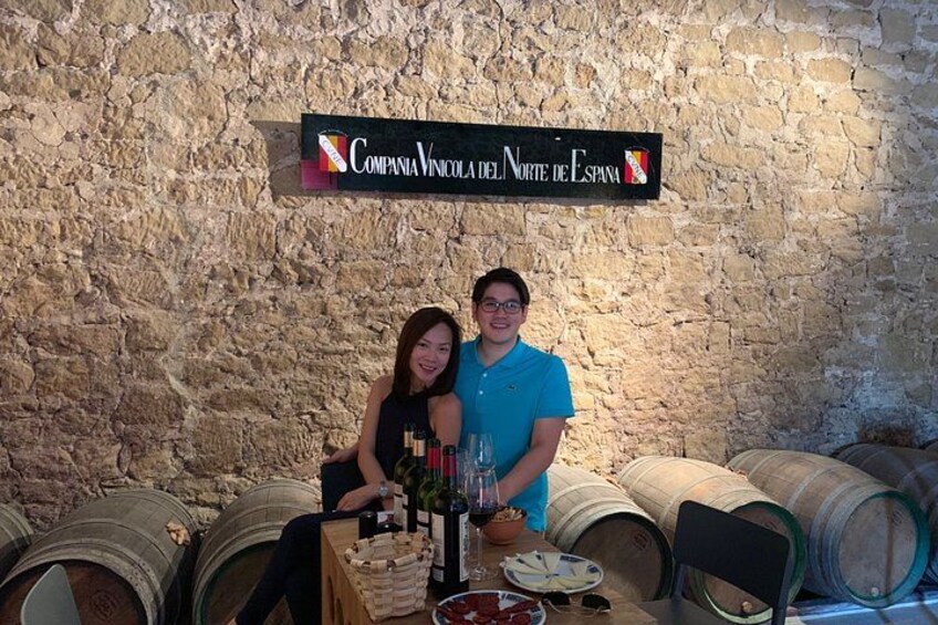 A wine cellar with barrels and a sign that reads 'Compania Vinícola del Norte de España'. 2