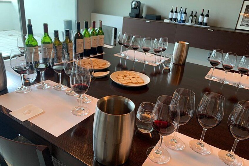 A wine tasting event with multiple wine bottles and glasses on a table. 4