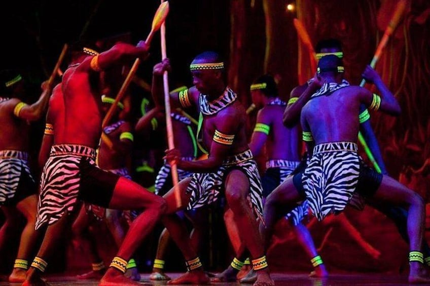 Een groep dansers in traditionele kostuums treedt op in een theater. 2