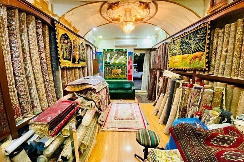 A carpet store with various rugs and carpets displayed on shelves and tables. 2