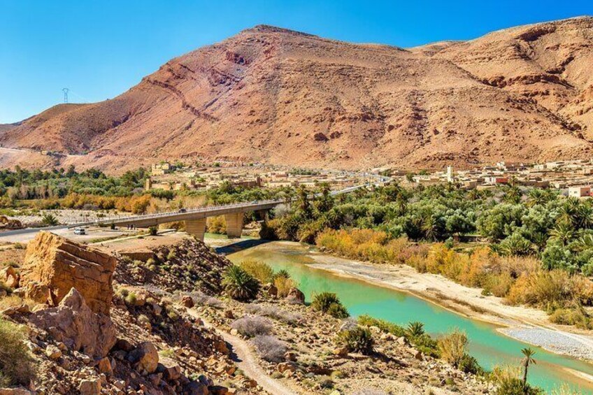 A mountainous landscape with a river, a bridge, and a town. 3