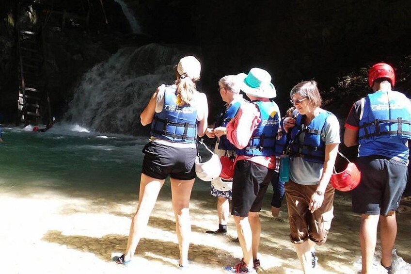 Un grupo de personas con chalecos salvavidas cerca de una cascada. 4