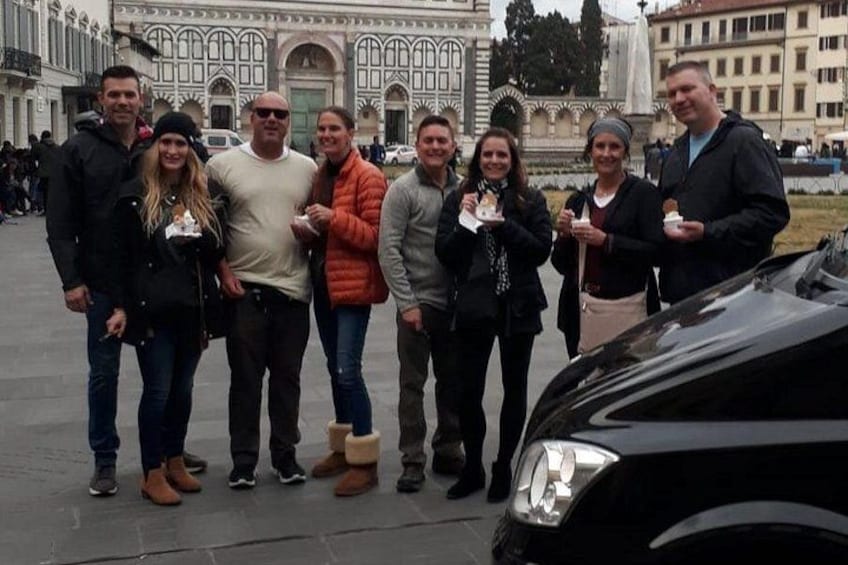Un gruppo di persone in una piazza pubblica, con un edificio sullo sfondo. 4
