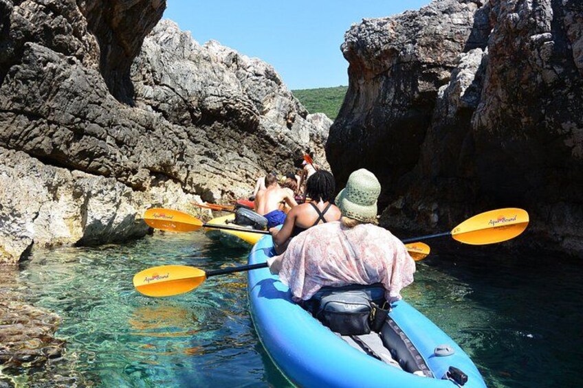 People kayaking in a rocky coastal area. 3