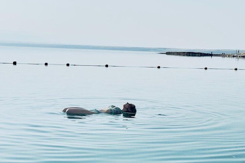 A person floating on water with a rope barrier in the background. 2