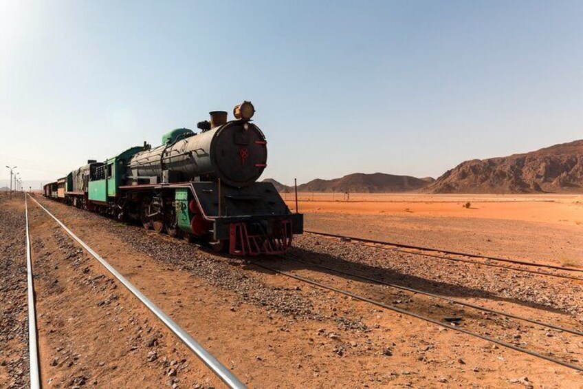 A steam locomotive on a railway track in a desert landscape. 5