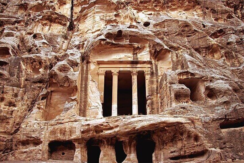 A rock-cut temple with columns and a central doorway. 3