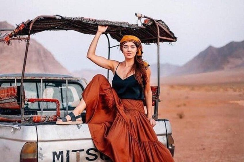 A person sitting on a vehicle with a desert landscape in the background. 5