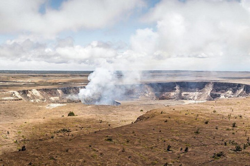 Un paisaje árido con un cráter grande que emite vapor. 2