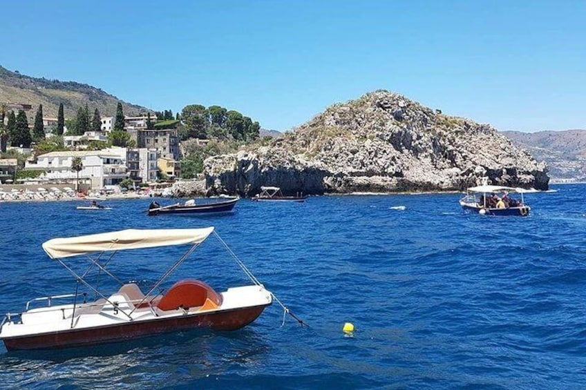 A coastal scene with boats, rocky terrain, and buildings. 4