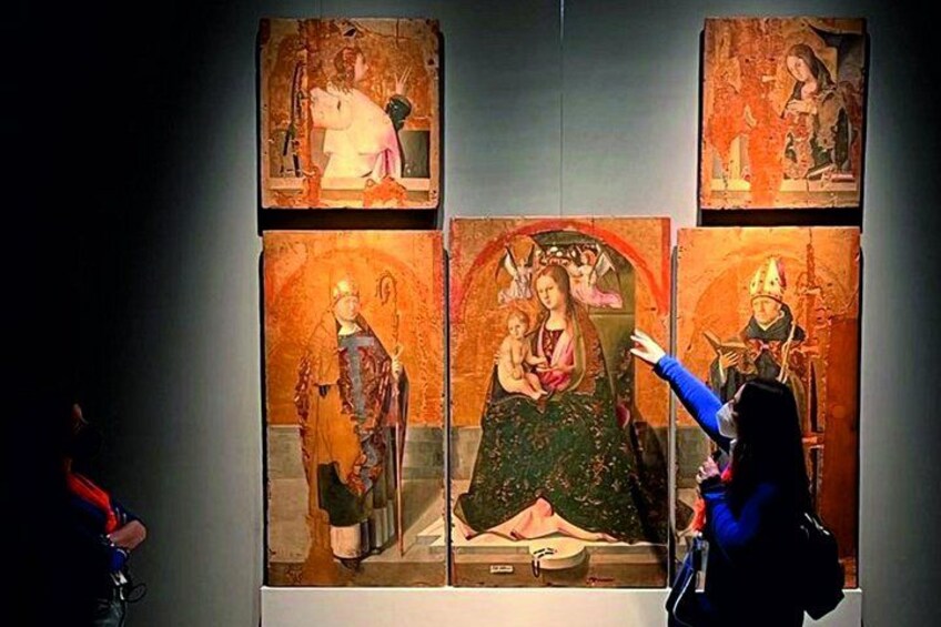 A person taking a photo of a religious painting. 1