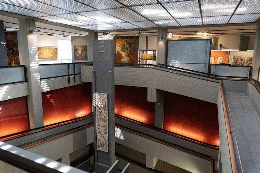 A multi-level atrium with artwork and red cushioned seating areas. 2
