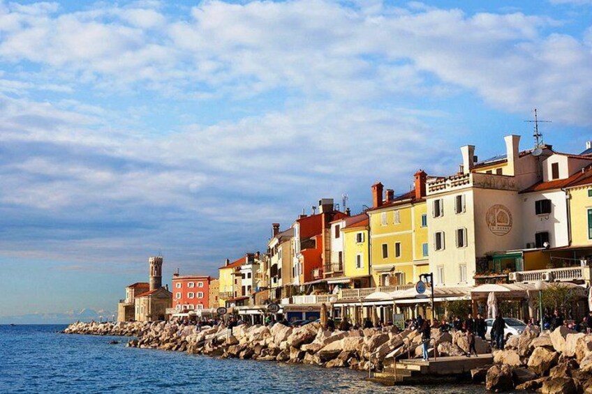 Une ville côtière aux bâtiments aux couleurs vives, avec un littoral rocheux et un ciel dégagé. 4