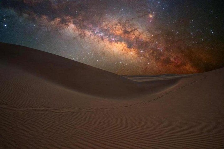 A desert landscape with sand dunes and a starry night sky. 3