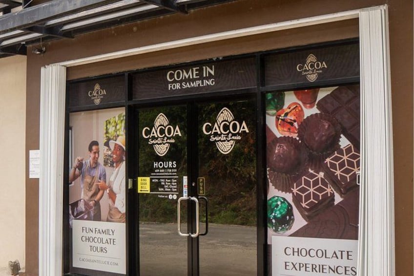 A storefront with a sign that reads 'Cacoa' and 'Come in for sampling.' There are posters advertising 'Fun Family Chocolate Tours' and 'Chocolate Experiences.' 3