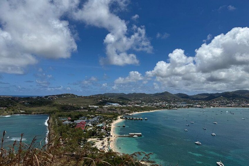 A coastal town with a beach, boats, and a clear blue sky. 3