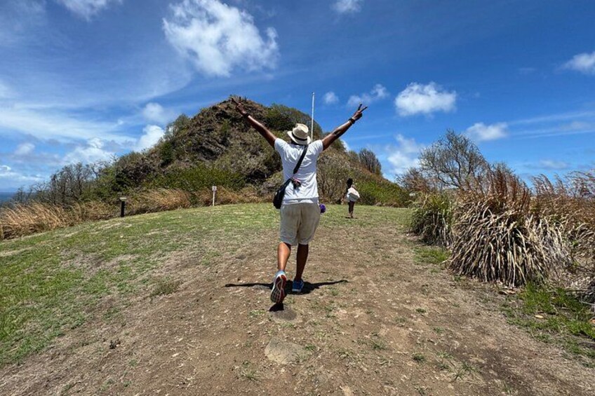 A person hiking on a dirt path with a hill in the background. 4