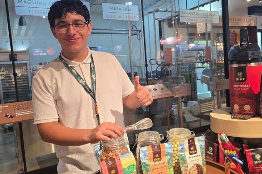 A person standing in front of a display of food products, including jars and packaged goods. 2