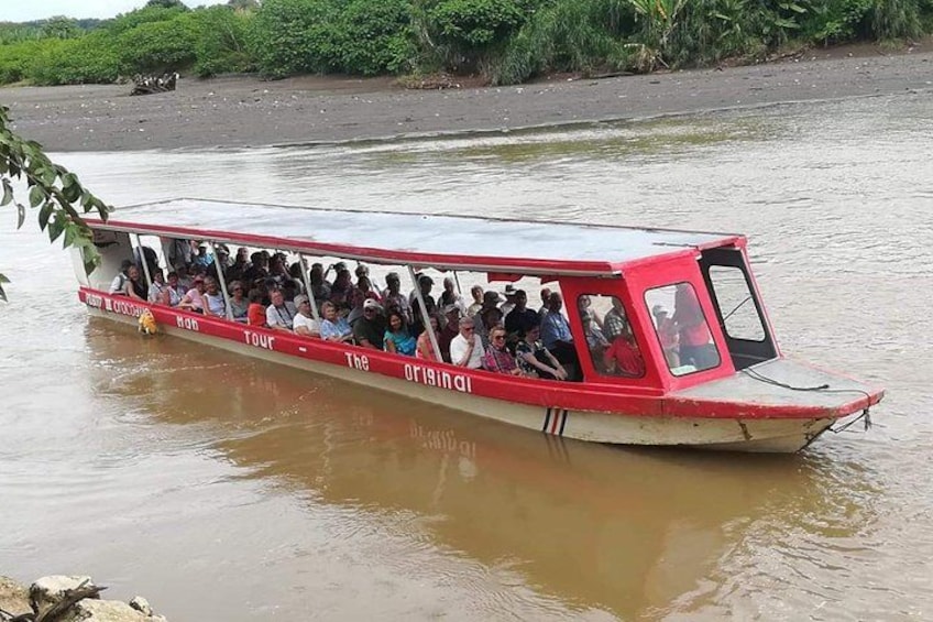 A red boat with 'The Original Tour' written on it, floating on a river. 5
