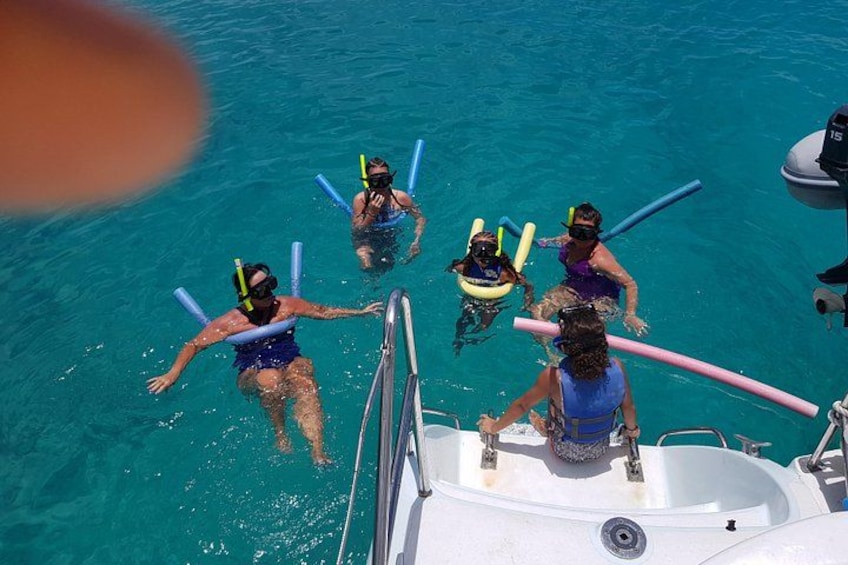People snorkeling in clear blue water with snorkels and fins. 2
