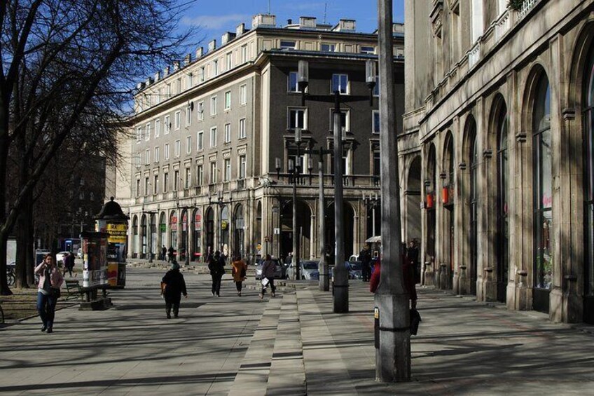 A city street with pedestrians, historic buildings, and a tram stop. 5