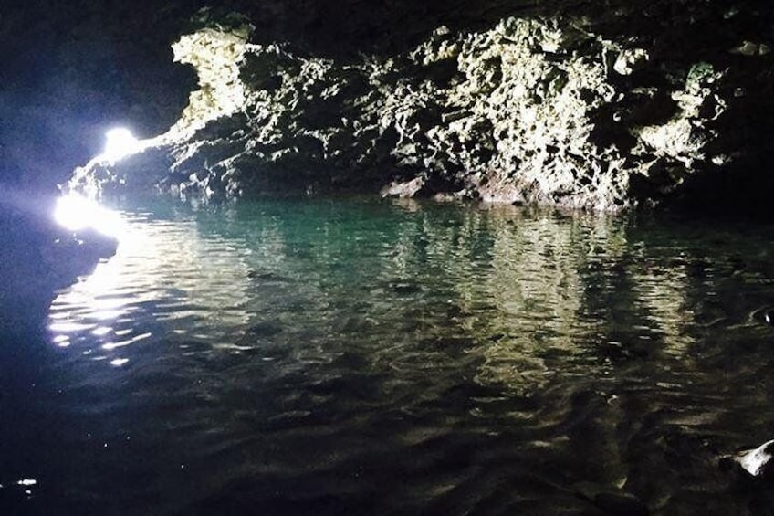 A cave entrance with water reflecting light. 1