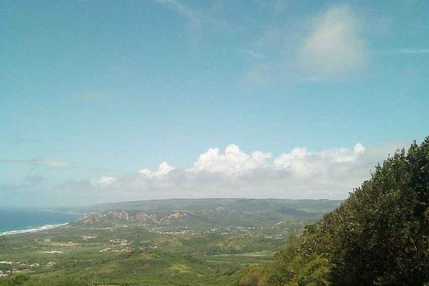 A coastal landscape with a view of the ocean, rolling hills, and a clear sky. 2
