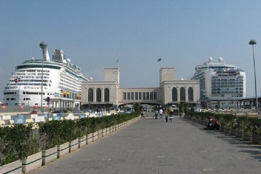 Un crucero amarrado en un puerto, con un edificio grande al fondo. 2