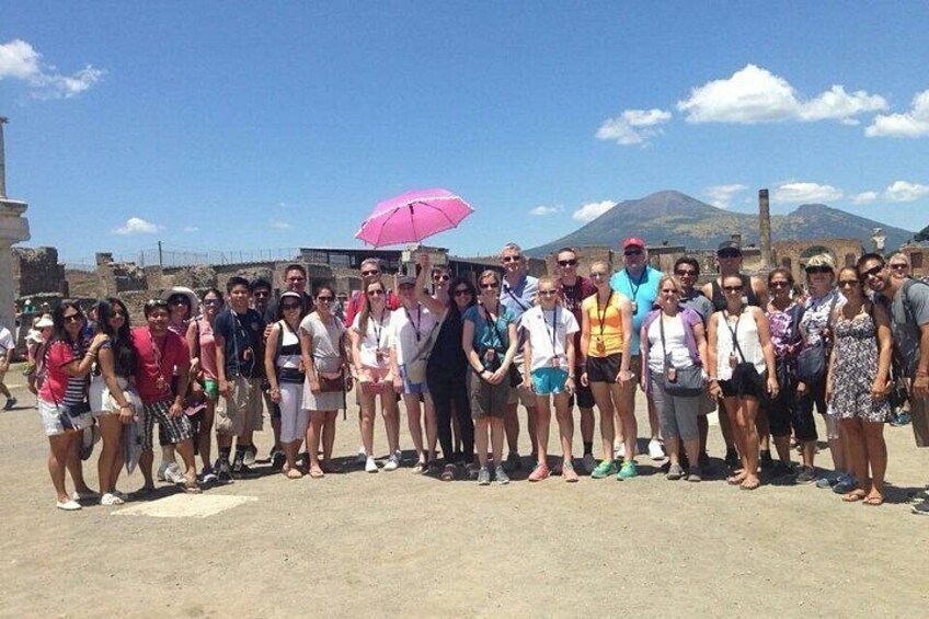 A group of people standing on a sandy area with a mountain in the background. 4