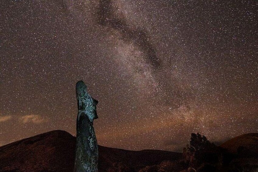 A starry night sky with a prominent meteorite in the foreground. 1