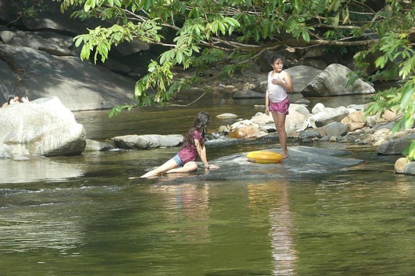 Dos personas en un río con rocas y árboles. 4