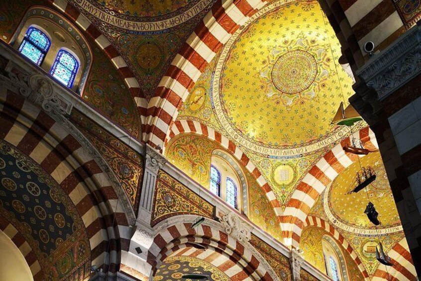 A cathedral interior with striped arches and ornate golden domes. 1