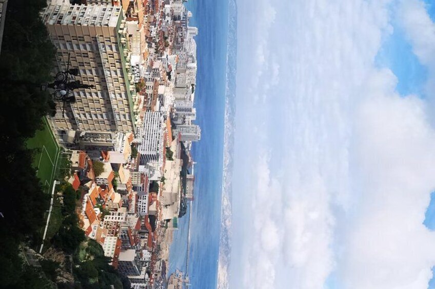 A coastal cityscape with buildings, a beach, and a clear sky. 5