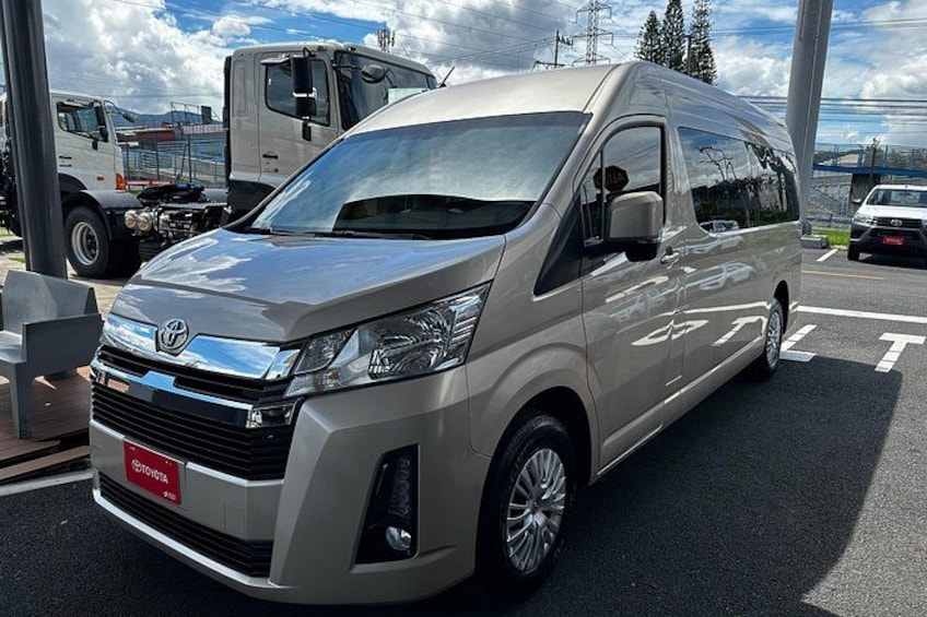 En Toyota Hiace-skåpbil stod parkerad på en parkeringsplats tillsammans med andra fordon. 2
