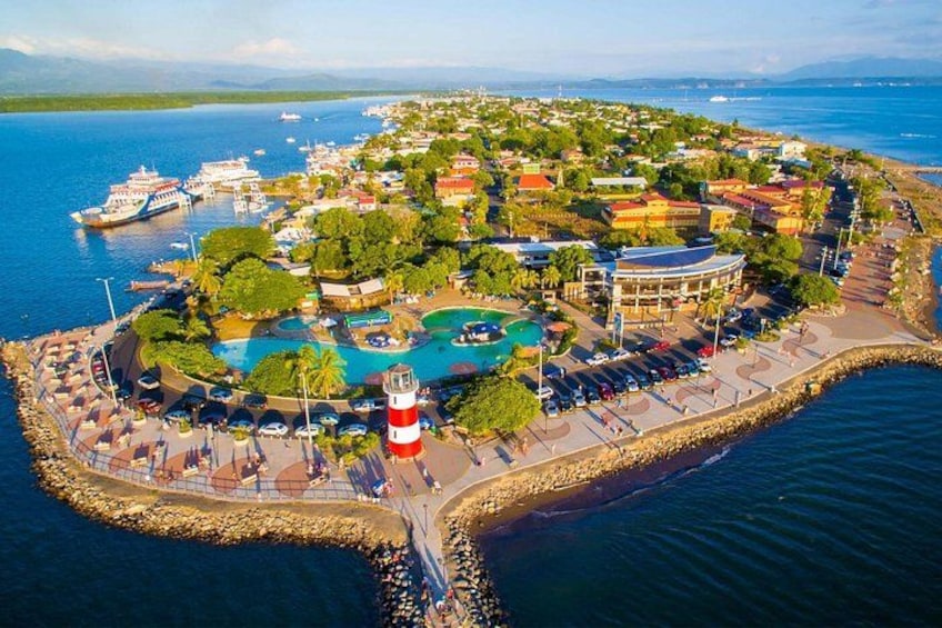 A coastal resort with a large pool, a lighthouse, and a marina with boats. 1