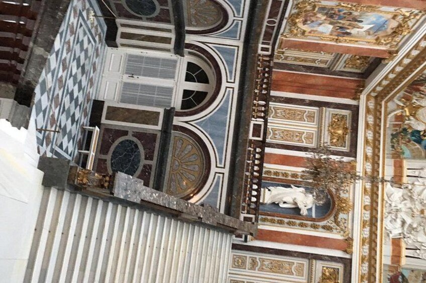 A detailed view of a building's ornate ceiling with intricate patterns and a statue. 3