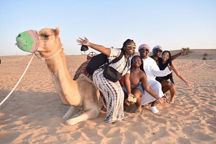 Eine Gruppe von Menschen reitet auf einem Kamel durch eine Wüste. 3