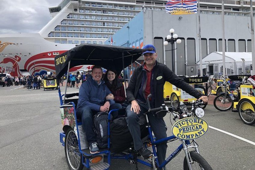 A person on a bicycle with a sign that reads 'Victoria Pedicab Company.' 2