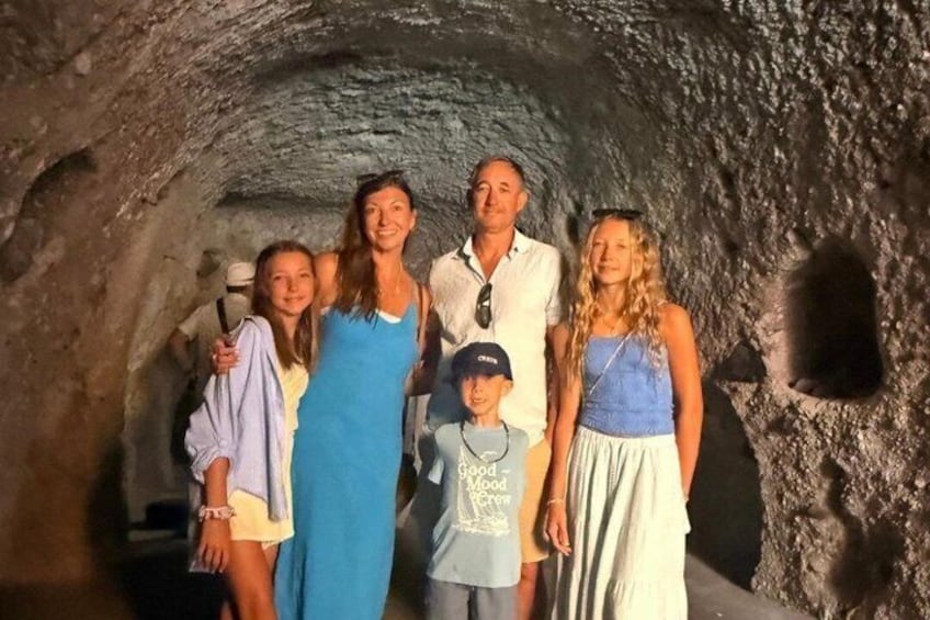 Un groupe de personnes se tient debout dans une grotte aux parois rocheuses. 3