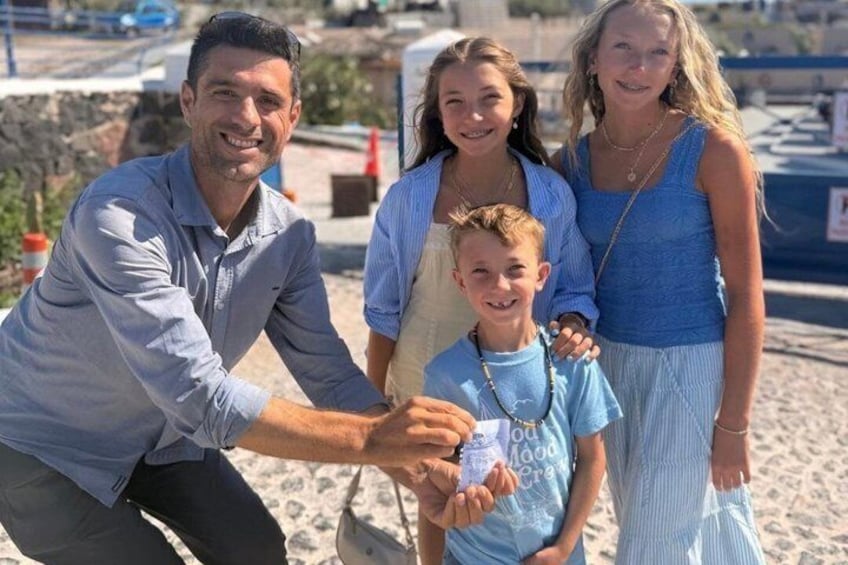 Una famiglia su una spiaggia, un bambino tiene in mano un sacchetto di plastica. 4