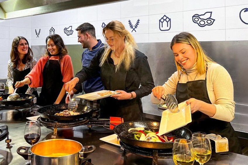 Un grupo de personas cocinando en una cocina con varias estaciones de trabajo y utensilios. 4