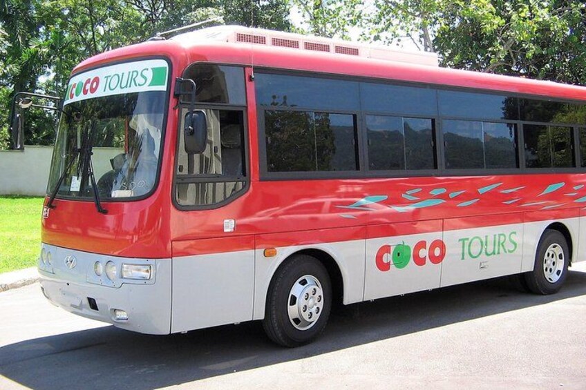 A red and white bus with 'COCO TOURS' branding parked on a street. 3