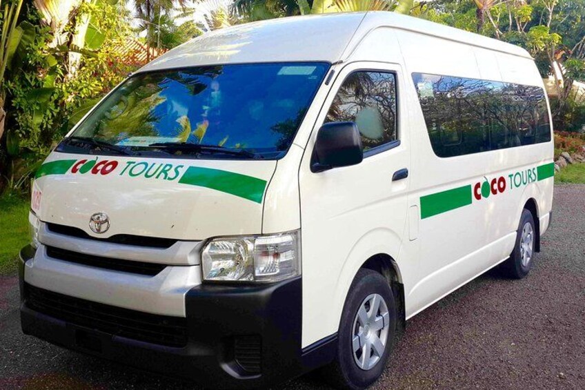 A white van with 'Coco Tours' branding parked on a road. 2