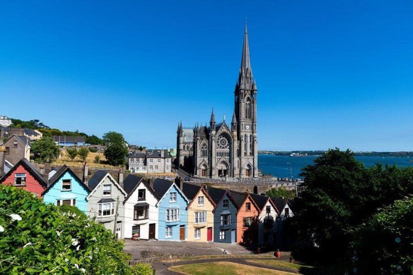 A coastal town with colorful houses, a prominent church, and a clear blue sky. 3
