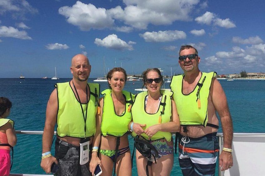 A group of people on a boat with life jackets, a clear sky, and the ocean in the background. 3