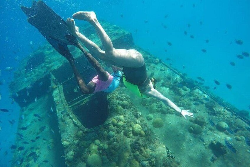 A person scuba diving near a submerged shipwreck. 5