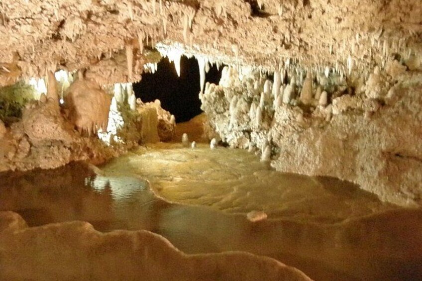Una cueva con estalactitas y una poza de agua. 3