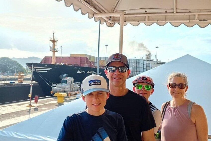 A group of people standing in front of a ship named MSC Anishar R. 1
